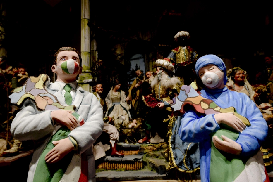 Le statue del presepe con la mascherina nel quartiere di San Gregorio Armeno a Napoli