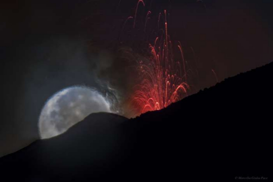 Uno scatto suggestivo della luna sull’Etna