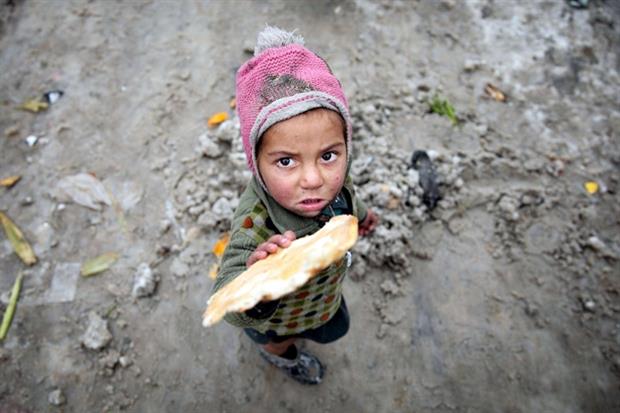 Il pane nelle mani di un bambino in un campo di rifugiati a Kabul