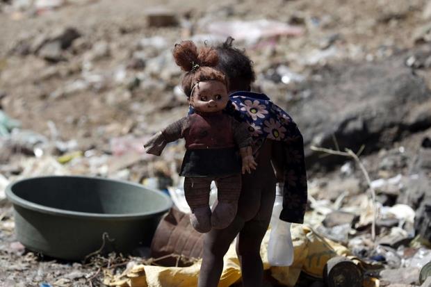 Una bimba tra i rifiuti e le macerie nel cuore della capitale yemenita, Sanaa