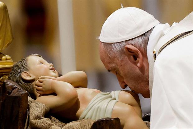 Il bacio del Papa a Gesù Bambino nella Messa della notte di Natale