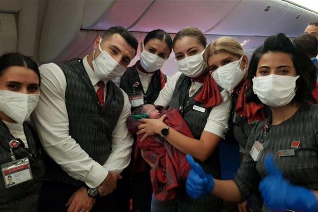 L'equipaggio del volo Turkish Airlines  gioisce con la neonata afghana  nata durante il trasbordo dei profughi dall'Afghanistan al regno Unito