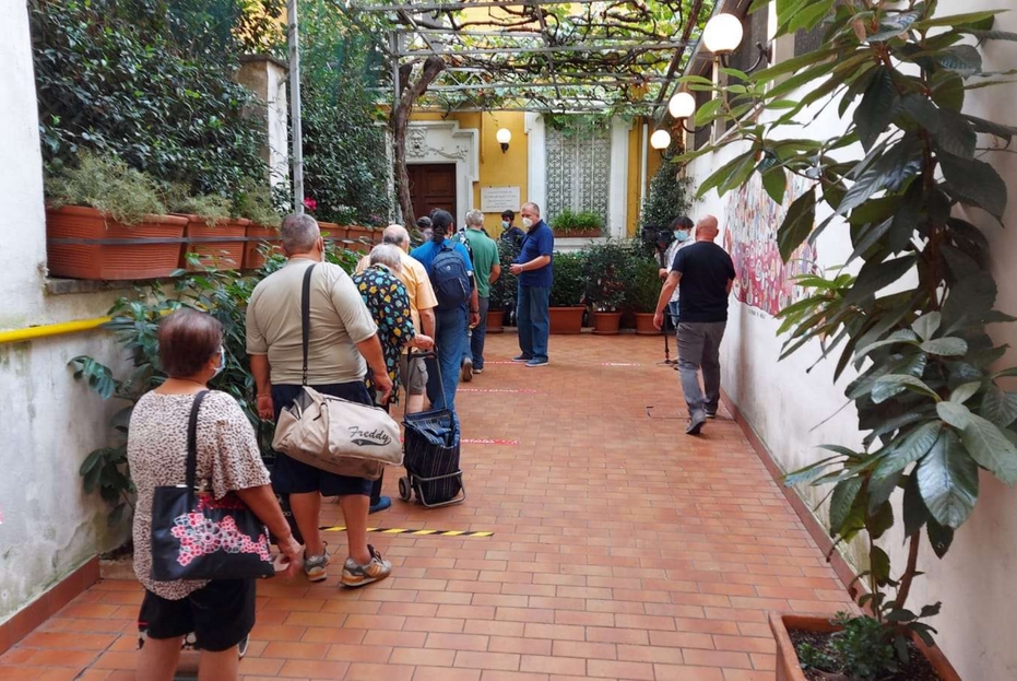 La coda delle persone in attesa di un pasto all’esterno della Comunità di Sant’Egidio a Roma