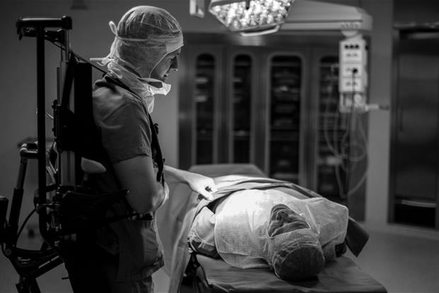 Marco Dolfin chirurgo mentre opera, aiutato da una speciale carrozzina