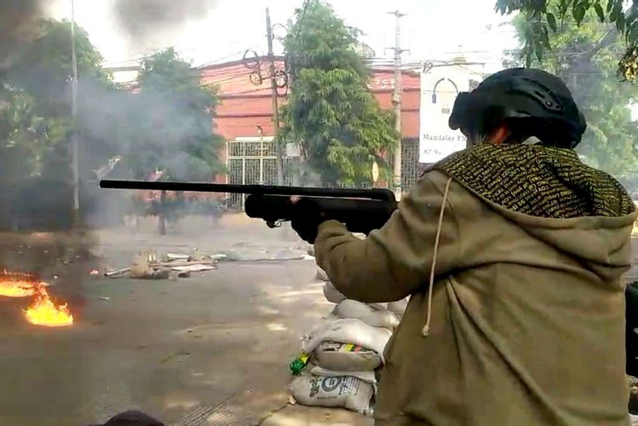 Un oppositore con un fucile ad aria compressa nelle strade di Mandalay