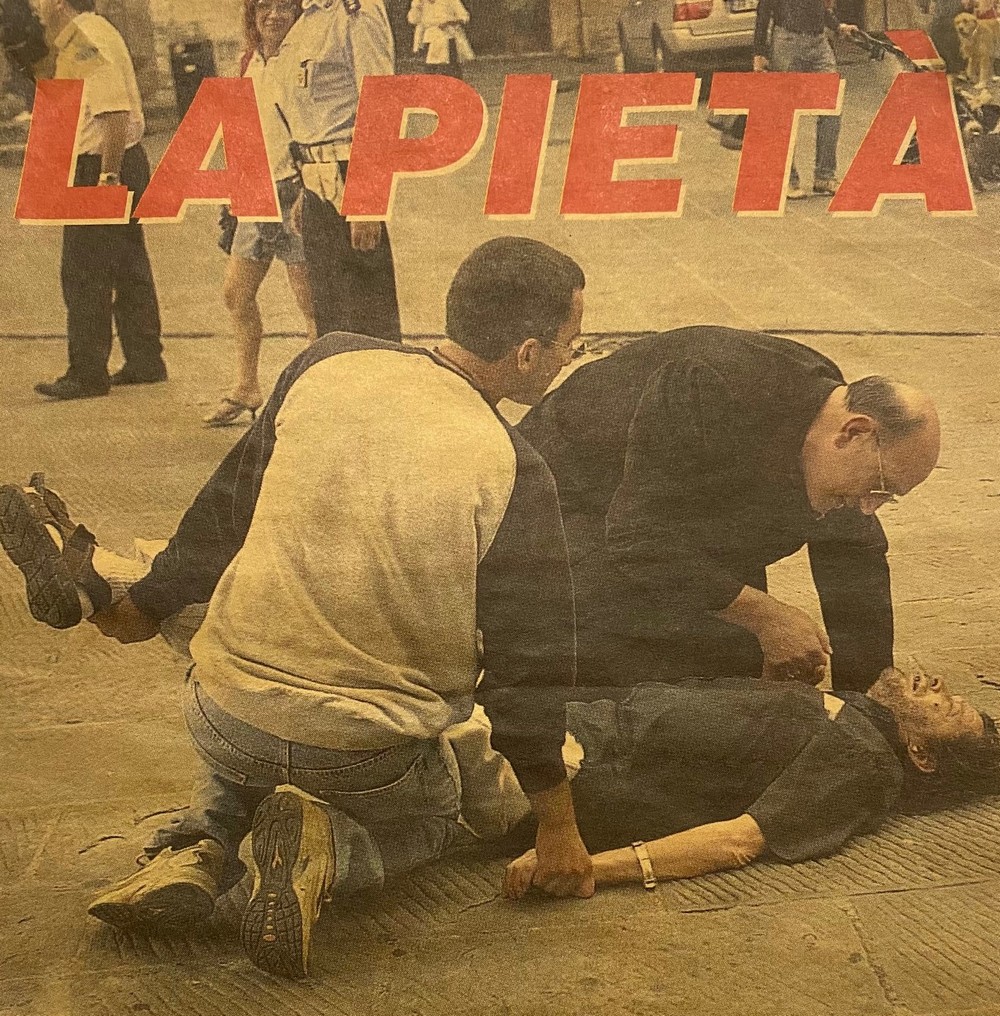 La pagina del quotidiano 'La Nazione' con l'arcivescovo Chiaretti che soccorre un uomo svenuto in piazza a Perugia