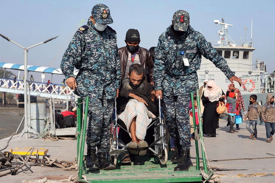 Un anziano invalido aiutato a imbarcarsi nel porto di Chittagong