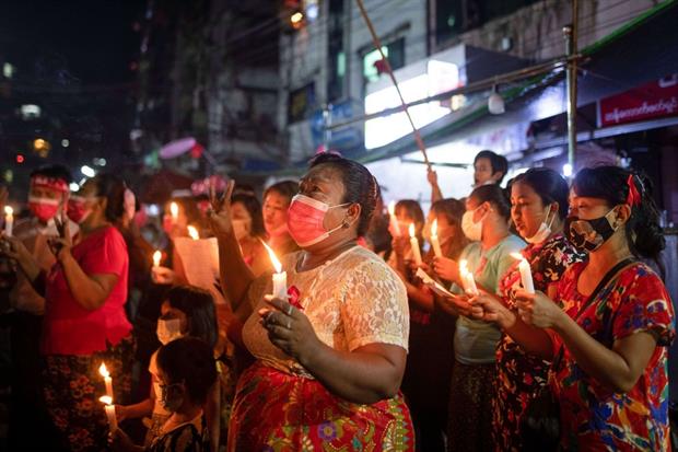 Donne con vestiti rossi in una veglia di protesta a Yangon