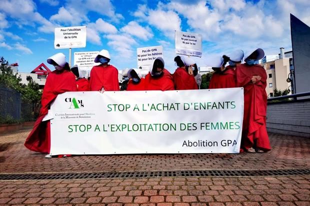Un momento delle proteste davanti al Salone di Parigi: le attiviste della Coalizione per l’abolizione della maternità surrogata vestite in rosso come 'ancelle'