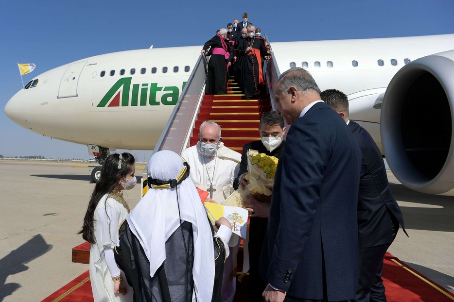 Due bambini in abito tradizionale hanno consegnato un omaggio floreale al Papa, una volta atterratto all'aeroporto di Baghdad