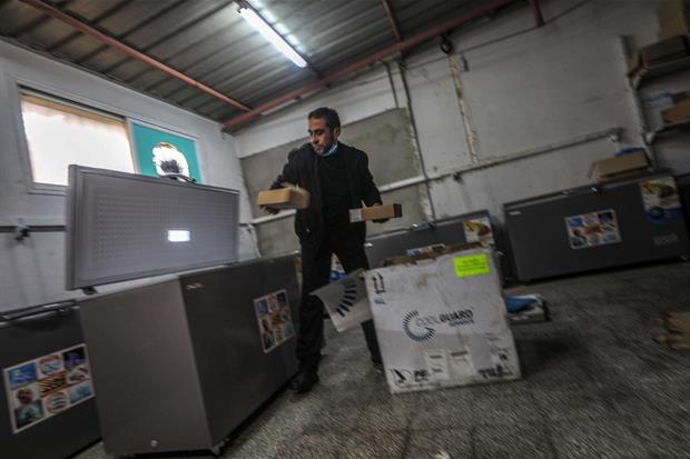Un addetto della Sanità palestinese mette i vaccini Sputink V in un frigorifero a Gaza City