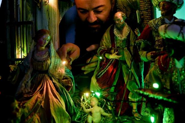 L'artigiano Genny Di Virgilio accende le lanterne verdi nel suo presepe