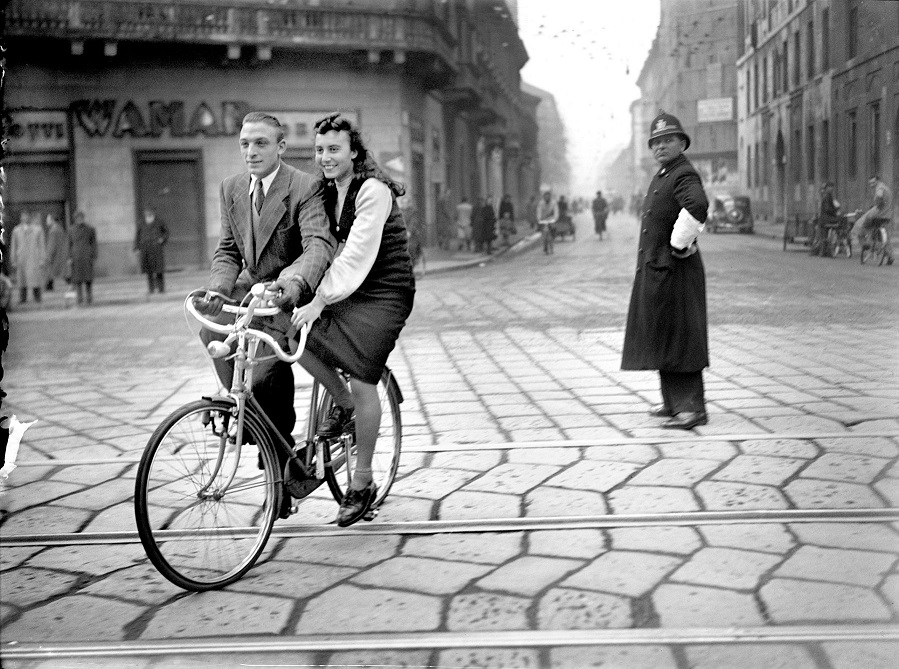 Un uomo e una donna in sella a una 'bici-coppia' a Milano, novembre 1947