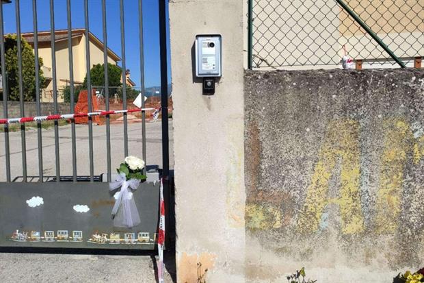 Una rosa bianca di fiori sul cancello chiuso della scuola d'infanzia dove è avvenuta la tragedia