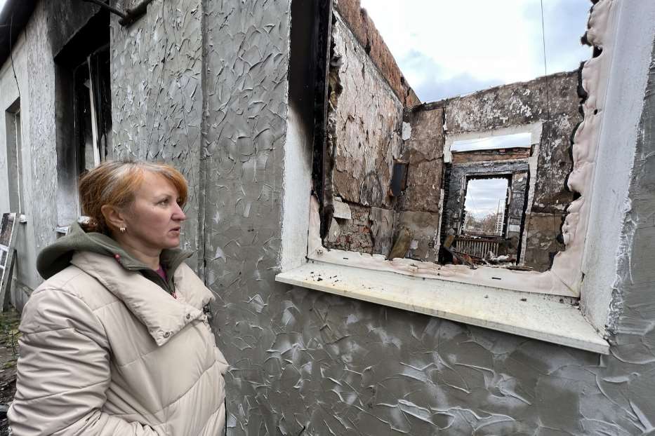 Svetlana di fronte a una casa distrutta a Slatyne
