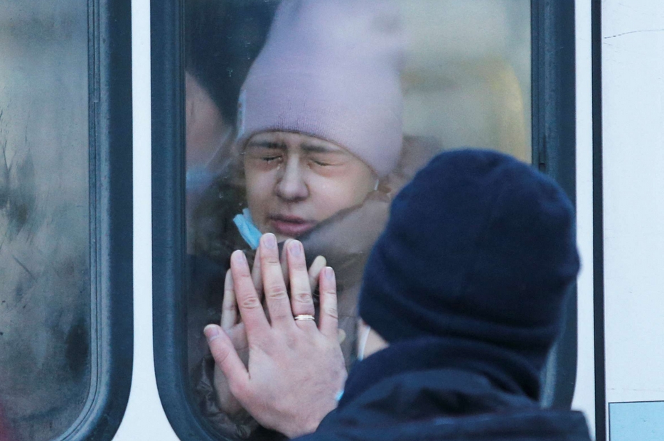 Una donna lascia Donetsk su un pullman diretto in Russia: ieri i separatisti, al suono delle sirene, hanno ordinato l'evacuazione dei civili