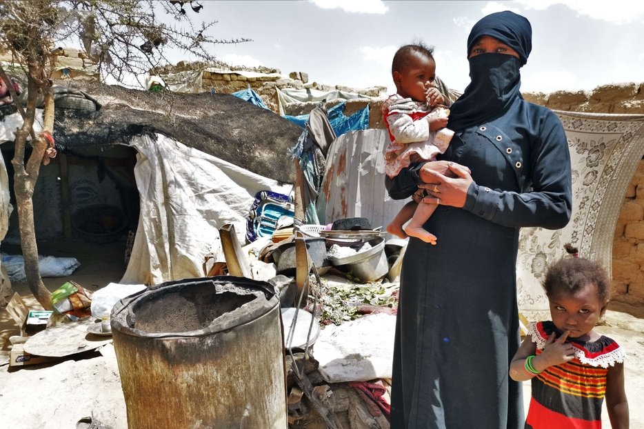 Una mamma con due bimbi in un campo profughi in Yemen