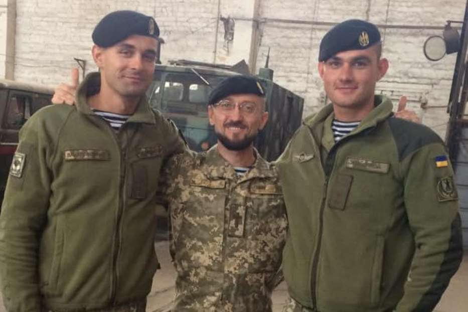 Padre Andriy Zelinskyy con due militari ucraini