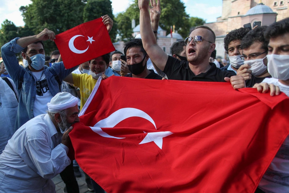 Un gruppo di musulmani a Istanbul con la bandiera turca