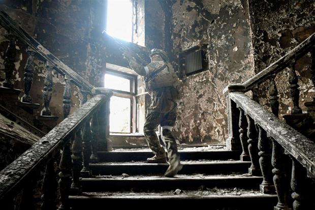Un soldato russo sulle scale del teatro-rifugio di Mariupol bombardato, 12 aprile. La foto è stata scattata durante un press tour organizzato dai russi
