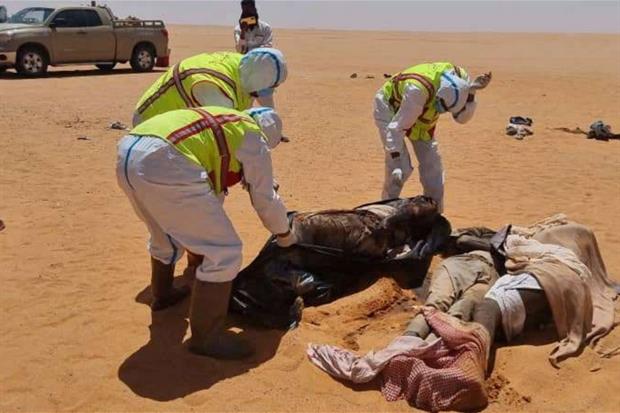 Gli operatori recuperano i corpi dei 20  migranti morti nell'area desertica libica di Kufra, oltre il confine con il Ciad.