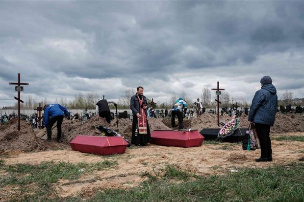 Il sacerdote Andrii Holovine celebra i funerali di 3 persone uccise a Bucha