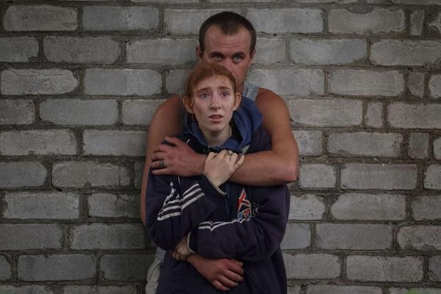 Alcune persone in attesa di avere notizie dei loro familiari fuori dal palazzo colpito a Chasiv Yar, in Ucraina. Finora 9 i sopravvissuti tratti in salvo, mentre continua la ricerca di altri dispersi