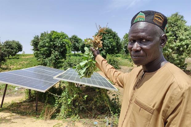 Sidy Sarr mostra i pannelli solari che alimentano l'impianto di irrigazione del suo campo agricolo