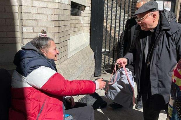 Il vescovo Sorrentino con un povero in strada vicino alla chiesa di San Francesco d'Assisi a Manhattan