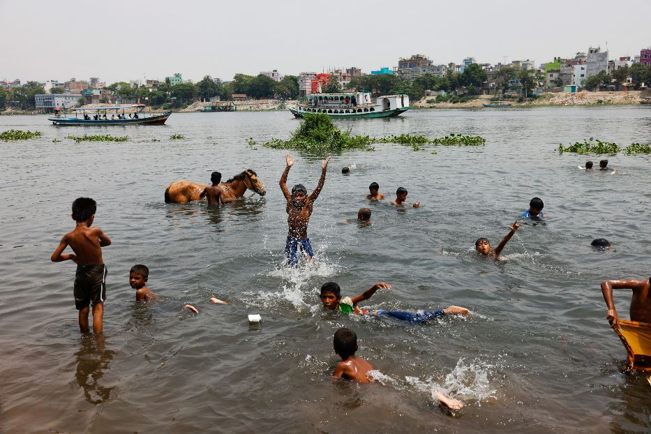 Bambini fanno il bagno nel fiume Buriganga nella capitale Dhaka