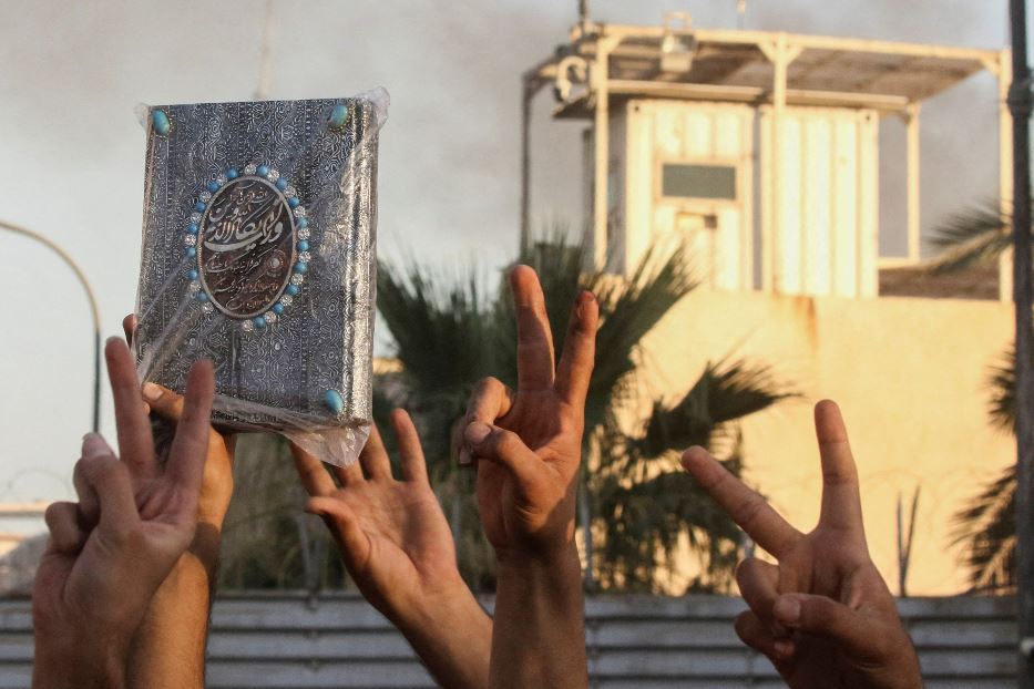 Manifestanti alzano il Corano dopo aver incendiato l'ambasciata svedese a Bagdad
