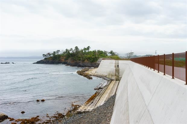 Kesennuma (Miyagi) - 2019.  Un poderoso muro anti-tsunami incombe sulla spiaggia Ooya. Prima dello tsunami questa spiaggia era rinomata per i suoi granelli di sabbia fine che la rendevano di aspetto quasi tropicale. Le comunità locali sostengono che la presenza del muro abbia danneggiato questo tipo di ambiente