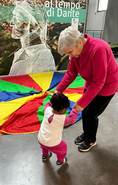 Una volontaria gioca con una bimba migrante all’hub del museo Classis