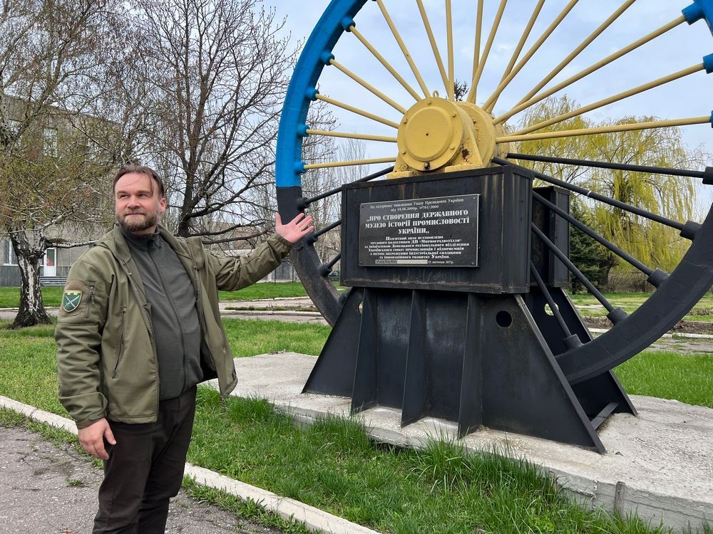 Padre Ivan Vasylenko davanti al simbolo della città di Myrnohrad