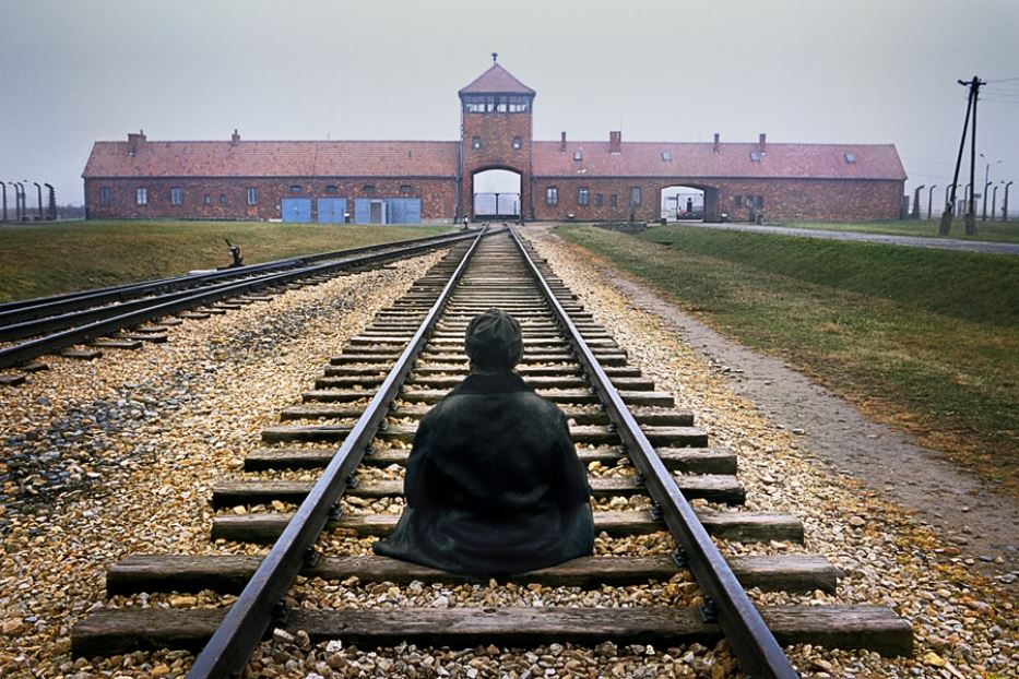 Un operatore di pace medita nel campo di sterminio nazista di Auschwitz-Birkenau, Polonia, 2005