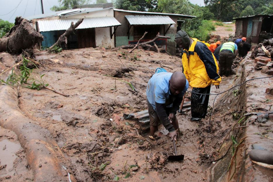 Un uomo scava nel fango in cerca di sopravvissuti o vittime a Chilobwe, nei pressi della città di Blantyre, in Malawi