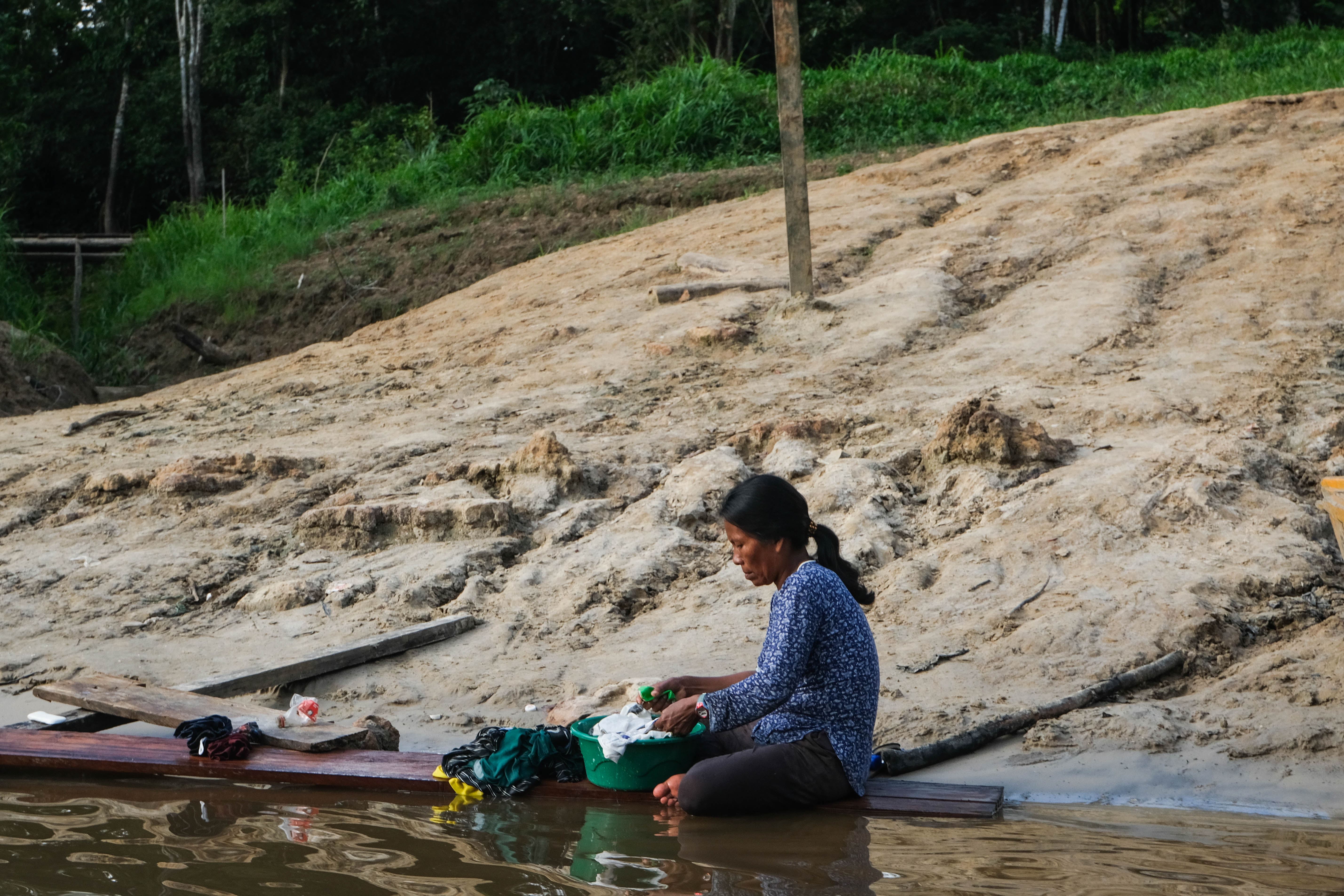 Una donna fa il bucato sull'argine del Rio de Amacayacu