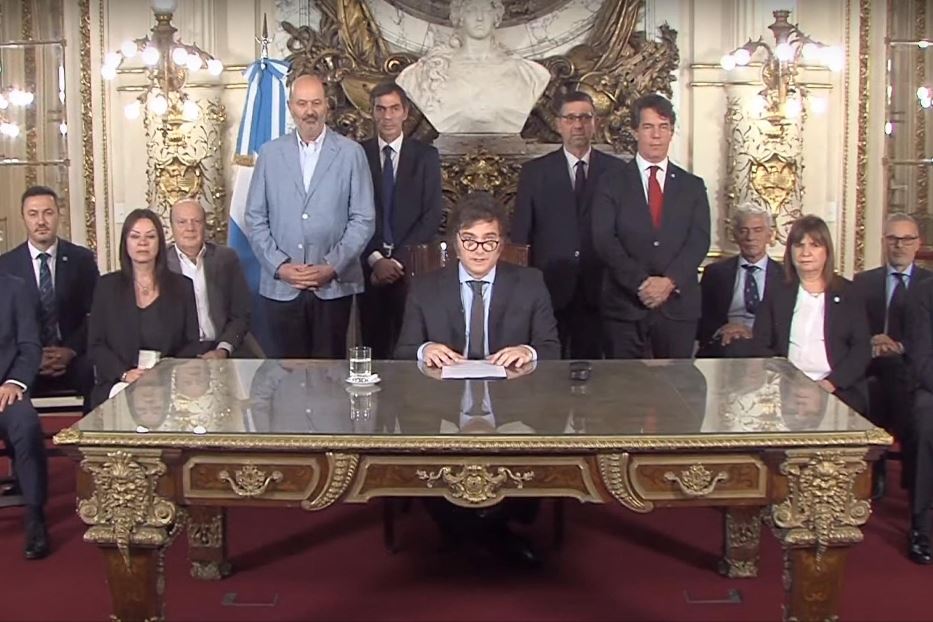 Il presidente Javier Milei (al centro) annuncia alla nazione il piano economico da una sala della Casa Rosada