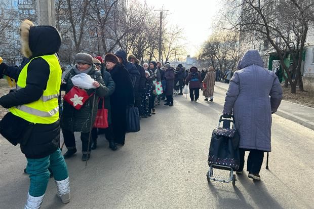 Gli ex sfollati tornati nel quartiere di Zhukovskogo a Kharkiv, in coda per il cibo distribuito dai volontari Caritas