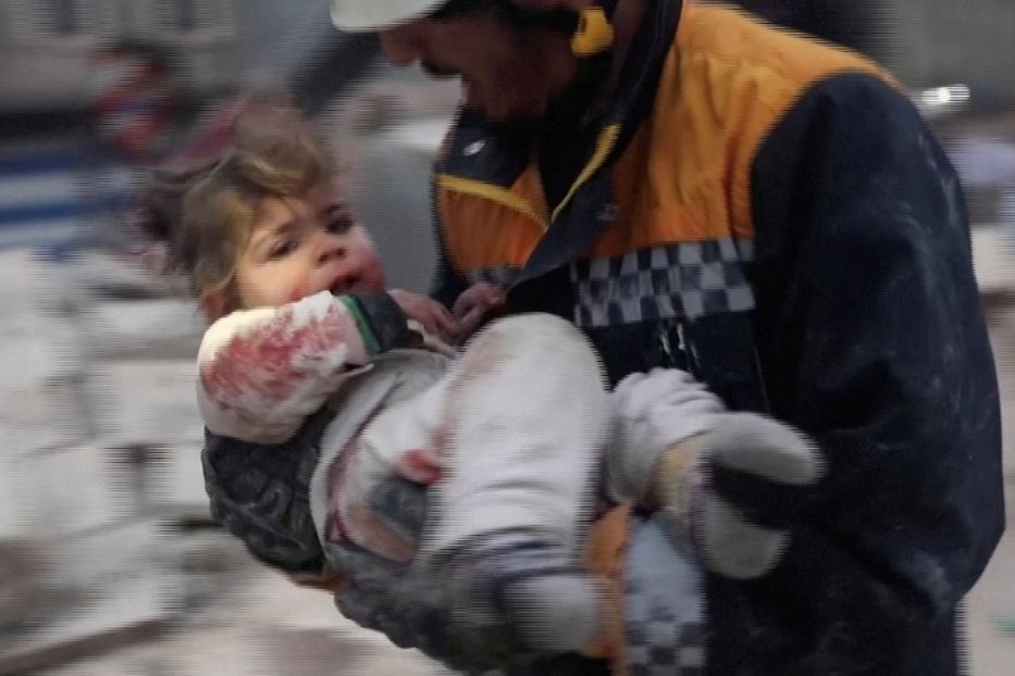 Un soccorritore con un bimbo in braccio nella cittadina siriana di Azaz controllata dai ribelli