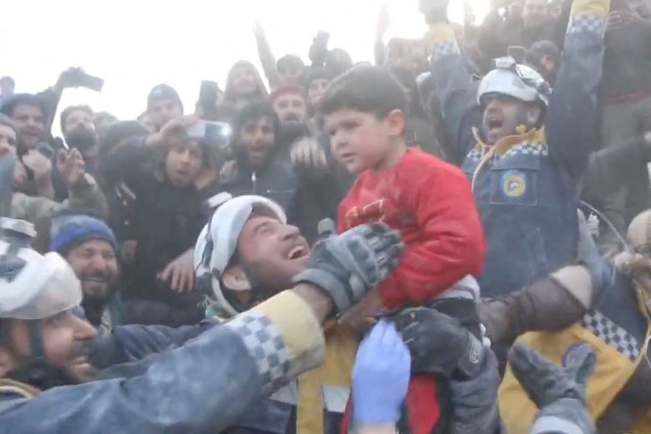 Esultanza per il salvataggio di un bimbo da sotto le macerie, a Bisnia in Siria. Con lui tratti in salvo anche il padre e la sorella