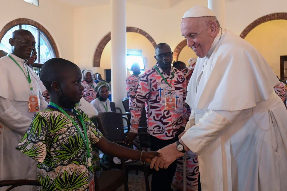 Un bambino, vittima della crudeltà che dilaga in Congo, stringe la mano a papa Francesco