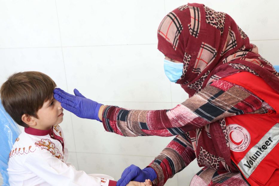 Un'infermiera afghana visita un bambino in un ambulatorio di Kandahr