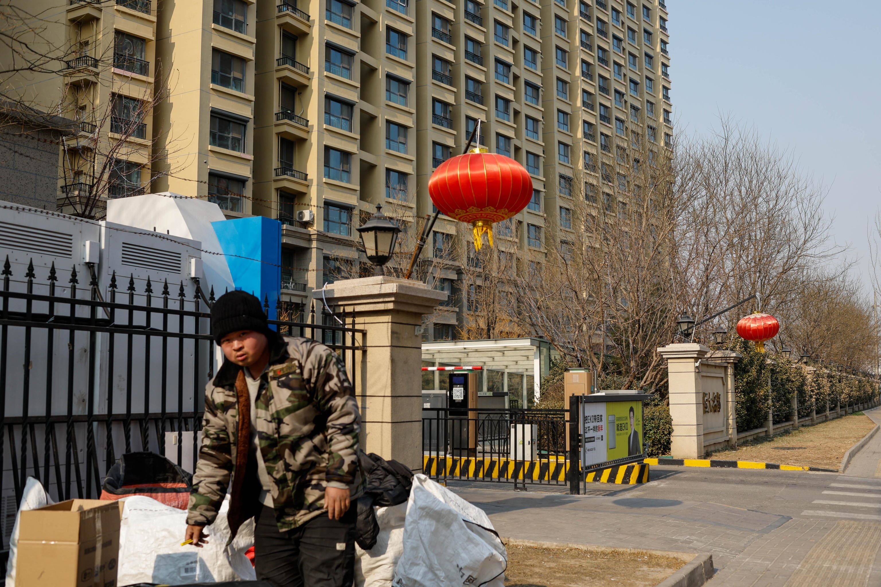 Un addetti alle consegne davanti a un complesso di Evergrande a Pechino