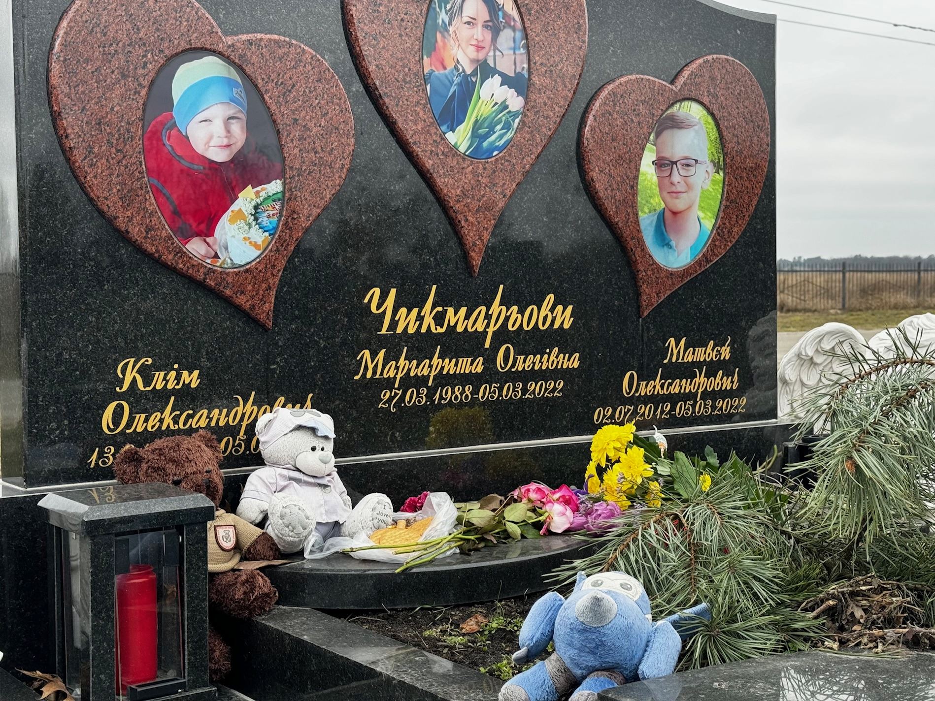 La tomba di tre bambini uccisi intenzionalmente nel marzo 2022. La gente di Bucha porta ancora giocattoli e biscotti