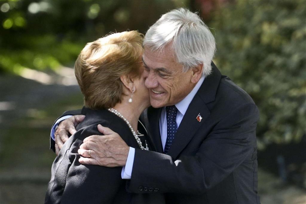 L’abbraccio fra la presidente uscente Michelle Bachelet e Sebastian Piñera (Ansa)