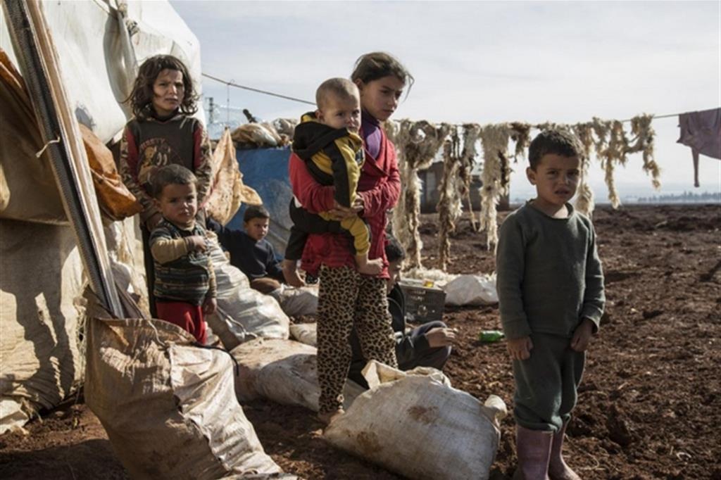 Bimbi sfollati dalla Siria in un campo in Giordania: le loro famiglie attendono un visto per gli Usa (Ansa)