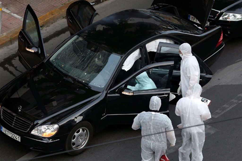 La polizia scientifica di Atene intorno all'auto in cui è stato ferito l'ex premier (Ansa/Ap)