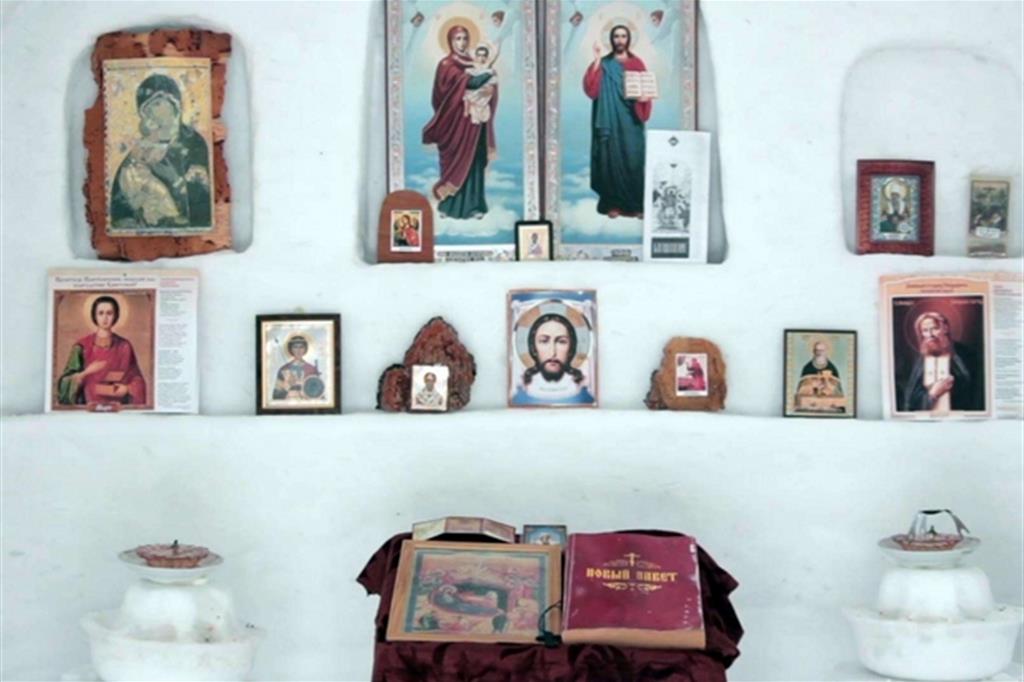 Le icone sacre e il piccolo altare nella chiesetta di neve (Ansa)