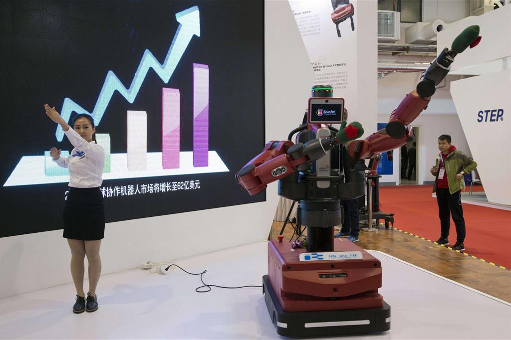 Alla fiera di robotica di Pechino una hostess mostra le capacità di Baxter, robot industriale dell'americana Rethink Robotics (Ansa)